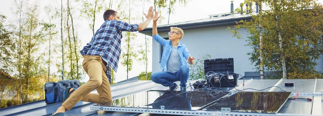 Father and Son Installing Solar Panels to a Metal Basis with a Drill. Eco friendly things you can do for your home.