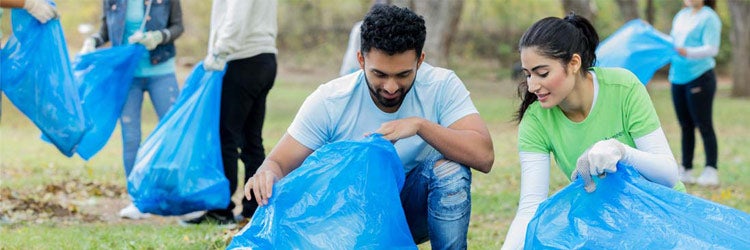 Volunteers in public park participating in community cleanup day. Find nonprofit insurance.