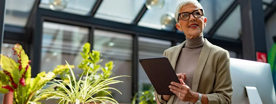 Businesswoman with Short Hair Standing outside and Holding a Digital Tablet. Compare business insurance.