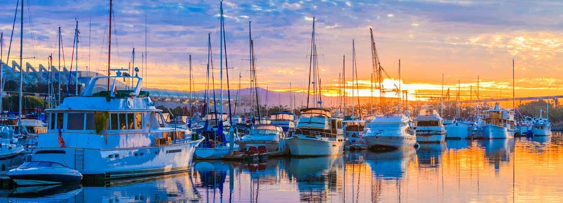 Boats in marina at dawn in San Diego Harbor, California. Find California boat insurance.