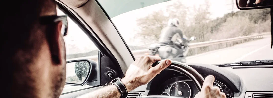 Man driving his Car with motorcycle overtaking. Motorcyclists: 8 Tips to Reduce Your Risk of Being Hit by a Car.