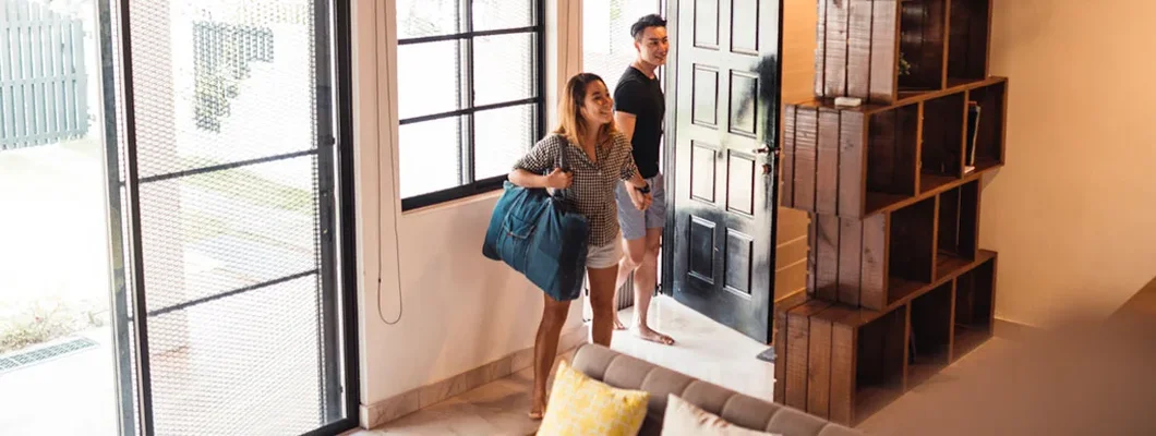 Young couple entering their house rented for vacation. Find Airbnb Landlord Insurance. 