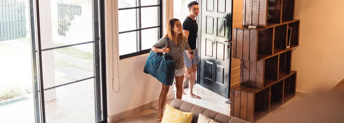 Young couple entering their house rented for vacation. Find Airbnb Landlord Insurance. 