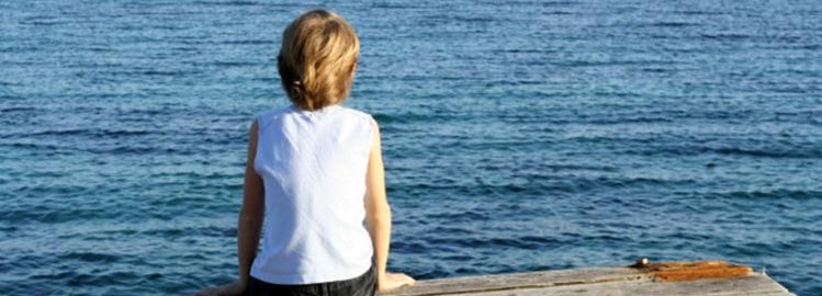 Boy sitting on a dock