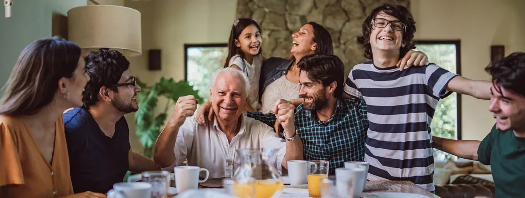 Happy smiling grandfather surrounded with his big family at breakfast. The Best Way To Choose a Life Insurance Beneficiary.