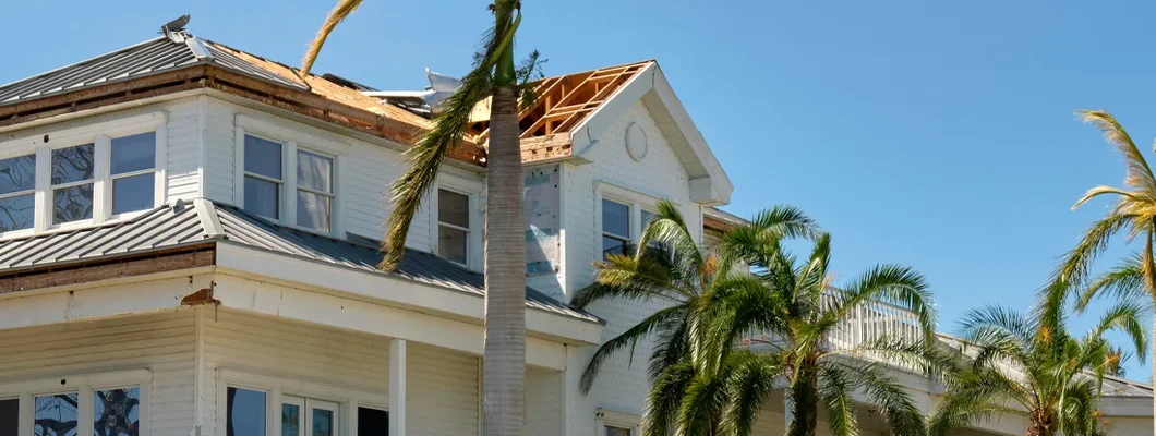 Damaged house roof after hurricane in Florida. How to calculate home replacement cost.