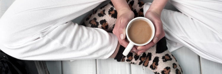 teenager sitting on floor holding a cup of coffee