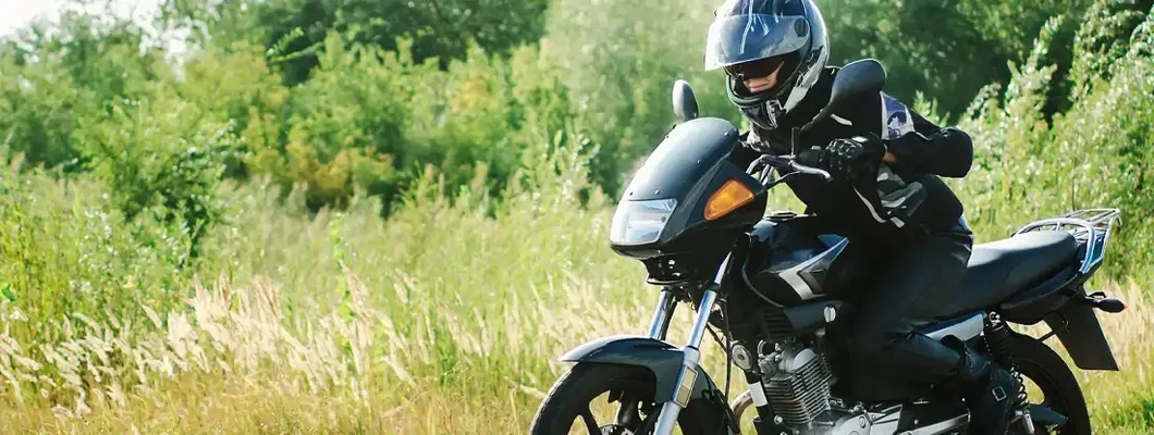 Biker woman riding sport motorbike on road. Find Tennessee Motorcycle Insurance.