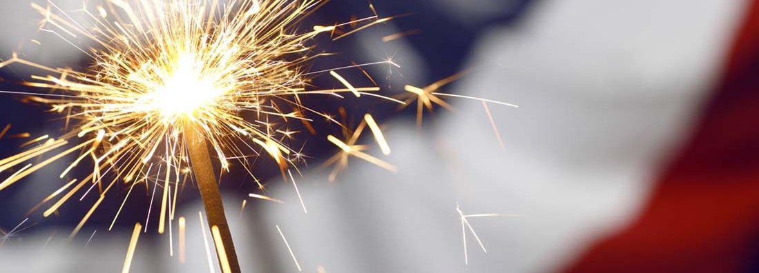 Sparklers in front of red white and blue bunting at fireworks store