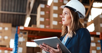 Woman using a digital tablet while working in a warehouse. Finding the Best Contractor Equipment Insurance.