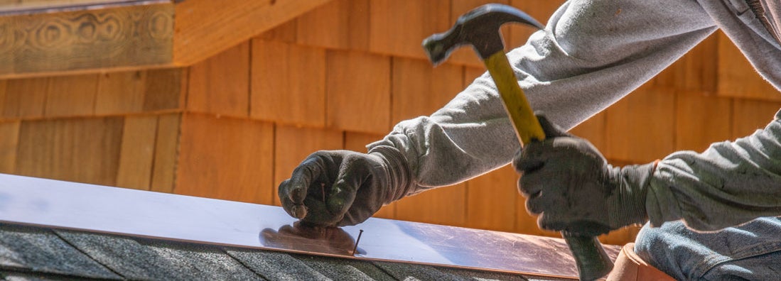 Roofer installing asphalt roof. Roofing license requirements by state.