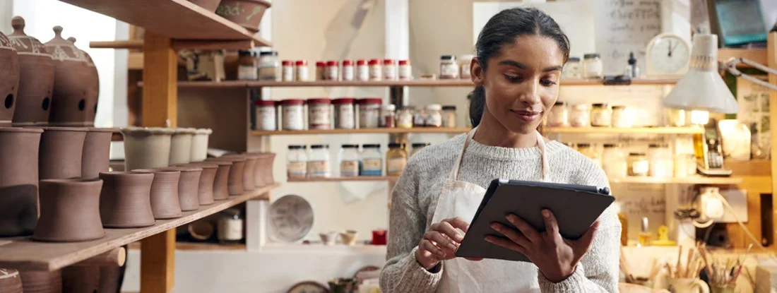 Female Potter In Ceramics Studio Checking Orders Using Digital Tablet. Best Small Business Insurance Companies.