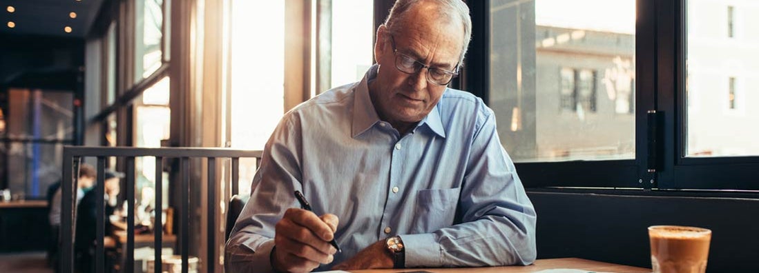 Mature businessman in cafe making notes. What Is a Standard Workers' Compensation Policy?