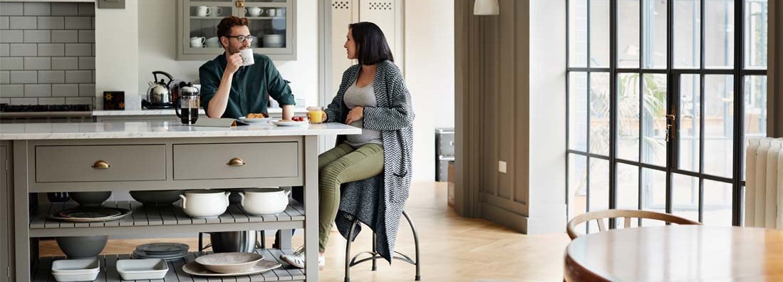 Young couple having breakfast together at new home