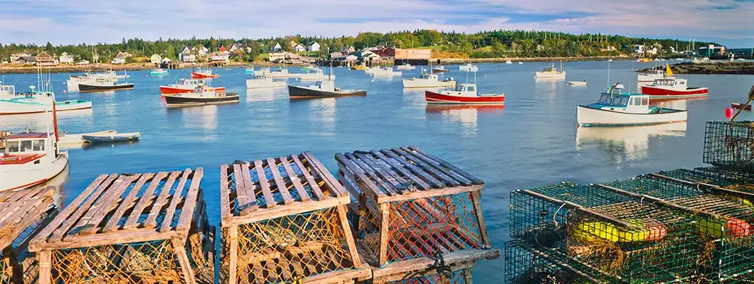 Wooden Lobster Traps On A Dock With Fishing Boats In Maine. Bath, Maine Business Insurance. 