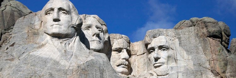 Close up view of Mount Rushmore under a blue sky