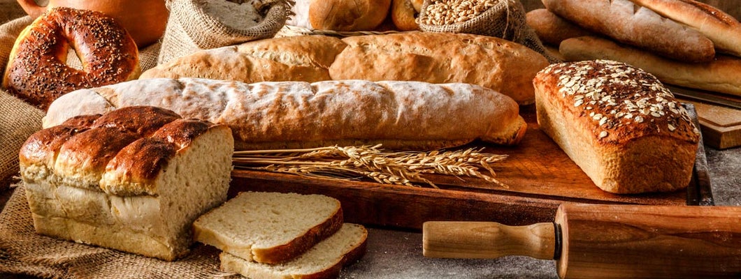 Different types of bread and rolling pin shot on rustic wooden table. Find Bakery Insurance.