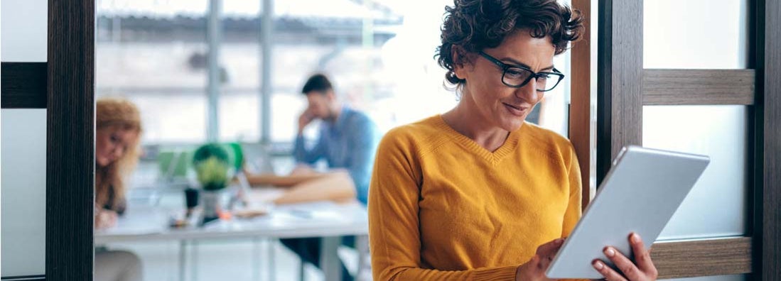 Business women using a tablet in the office. Compare business insurance.