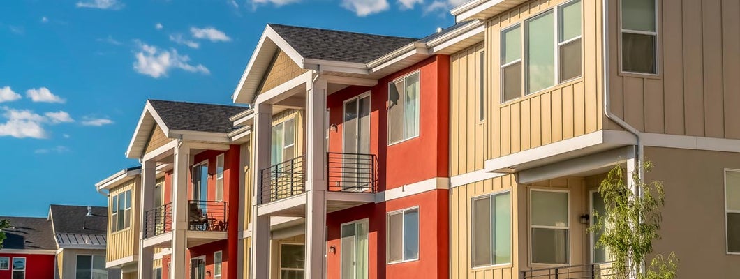 Colorful condominiums against cloudy blue sky. Find Virginia condo insurance.