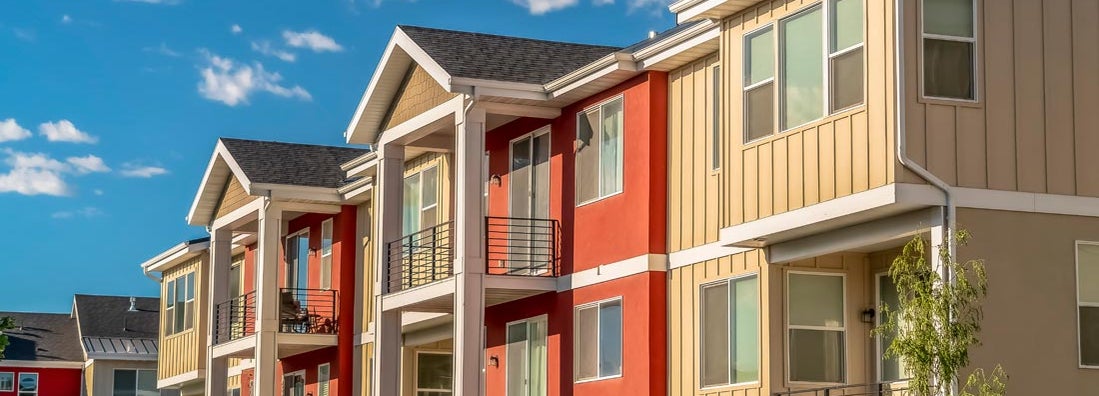 Colorful condominiums against cloudy blue sky. Find Virginia condo insurance.