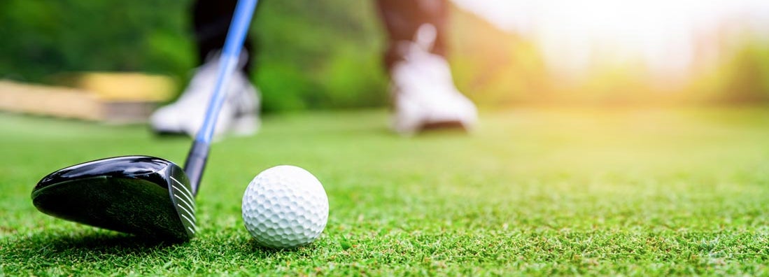 Close up golf ball on green grass. Find Golf course insurance.