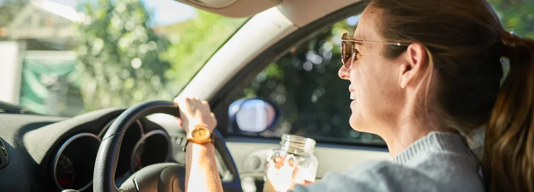 Smiling woman out for a drive in her car in the summer. How to Find the Best Car Insurance Policy in Whitefish Bay, Wisconsin.