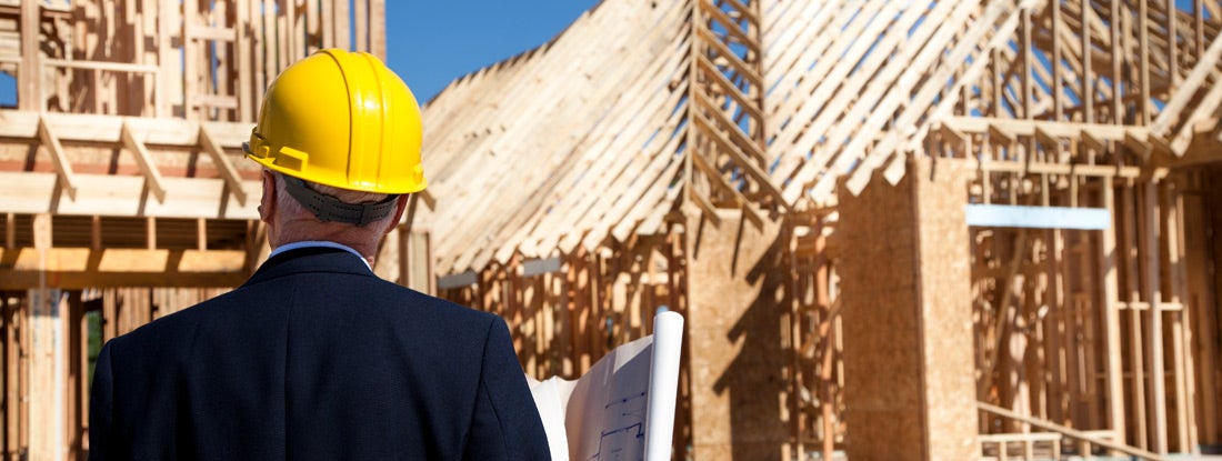 New home construction site with contractor in foreground
