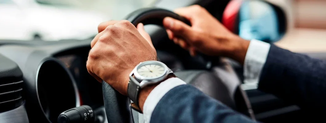 Cropped shot of man's hands on a steering wheel. South Portland, Maine Car Insurance. 