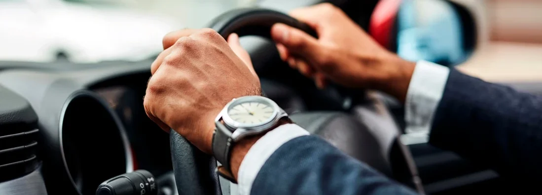 Cropped shot of man's hands on a steering wheel. South Portland, Maine Car Insurance. 