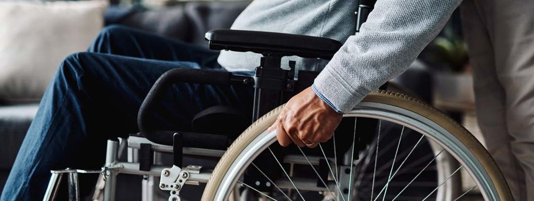 Low angle shot of man moving in his wheelchair  at home during the day. Find Individual disability insurance.