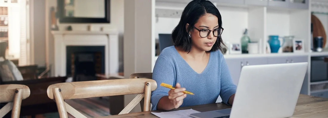 Woman using a laptop at home.  Understanding Home Insurance Claims.