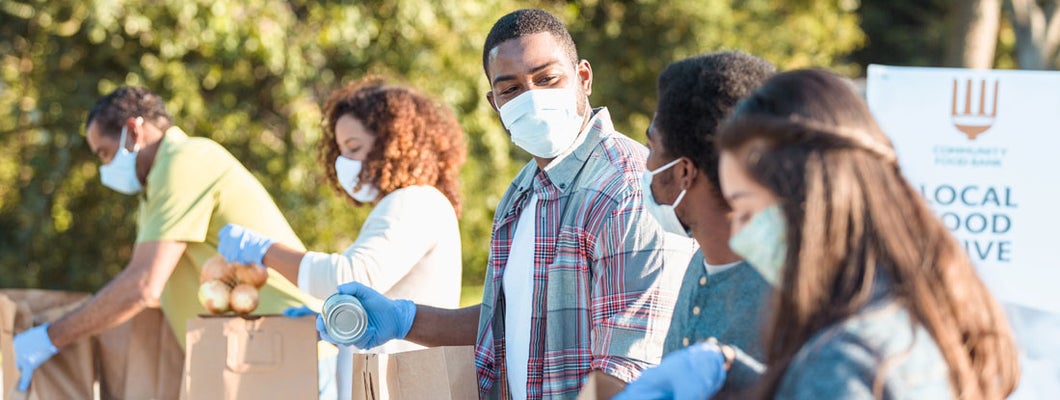 Community volunteers working at an outdoor food bank. Find Nonprofit Insurance.