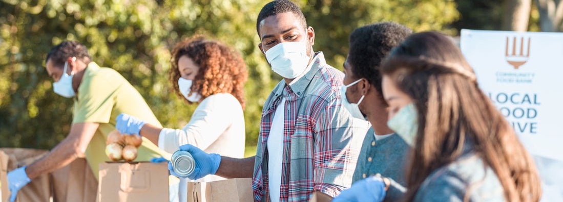 Community volunteers working at an outdoor food bank. Find Nonprofit Insurance.