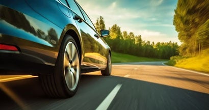 Car rushes along the highway at sunset. Find Cheap Car Insurance.