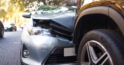 Two damaged vehicles in car accident after collision on city street. Find Collision Insurance.