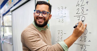 Male teacher explaining math in class. Professional Liability Insurance for Teachers.