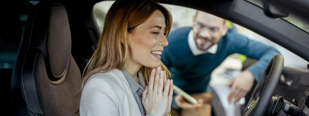 Woman sitting at the wheel of new car doing test-drive. Don't Skip the Inspection When Buying a Used Car. 
