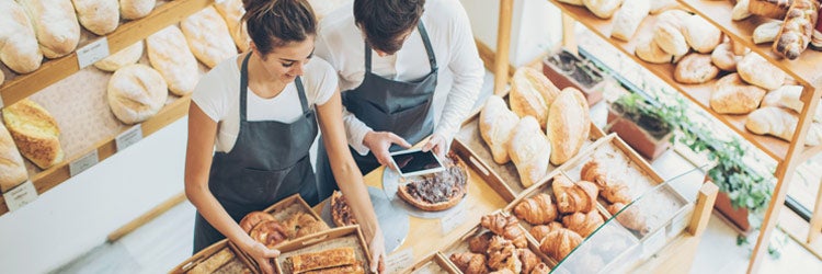 Top view of young couple of bakers inside the bakery. Find bakery insurance.