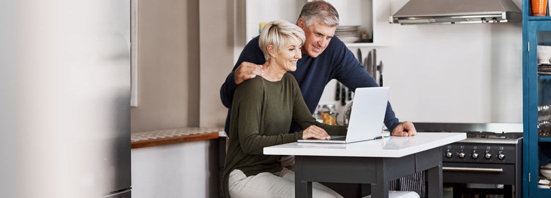 mature couple browsing fixed annuities on a laptop at home