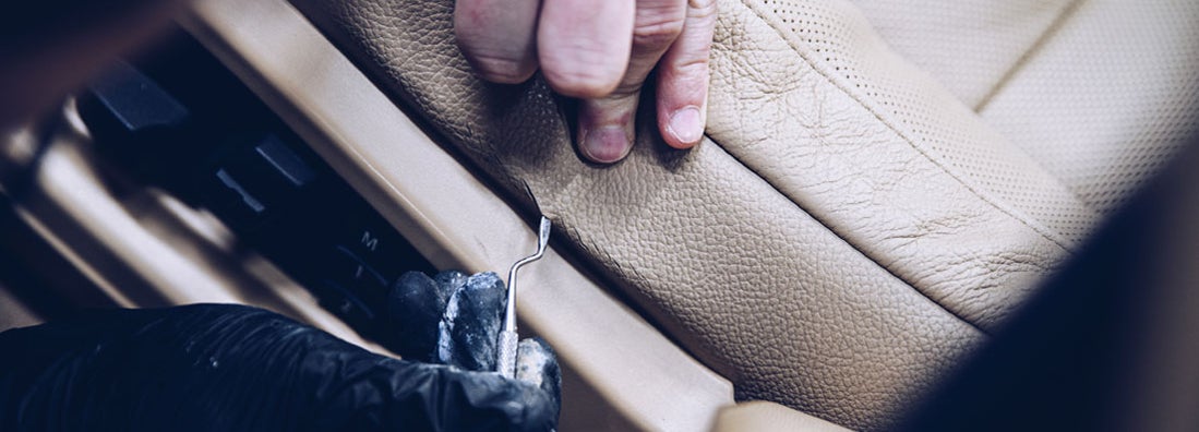 Car renovation studio worker renovating car leather seat. Find auto interior repair shop insurance
