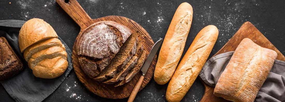 Homemade fresh baked various loafs of wheat and rye bread flat lay. Find commercial bread supply insurance.