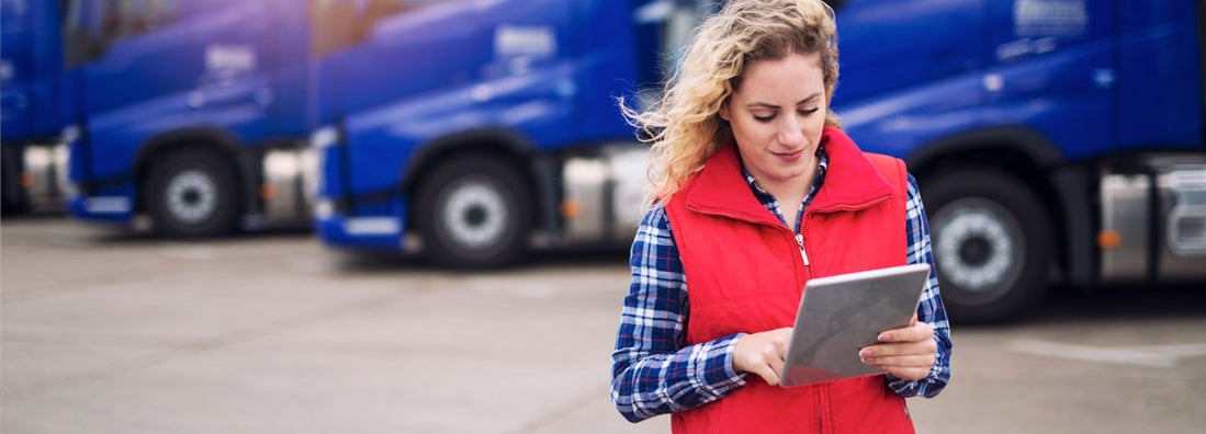 Truck driver holding tablet and checking route for new destination. Find Certificate of Insurance.