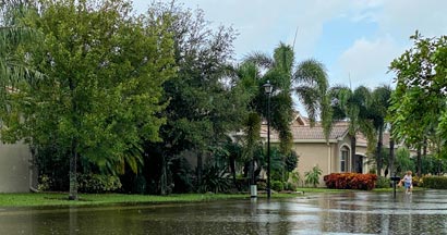 Flooded street in suburban Florida neighborhood. Why houses prone to floods are harder to insure in Florida.