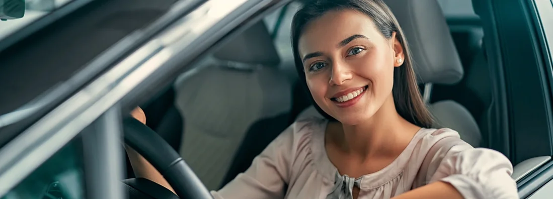 Tips for buying your first car. Young beautiful woman is choosing a new vehicle in car dealership.