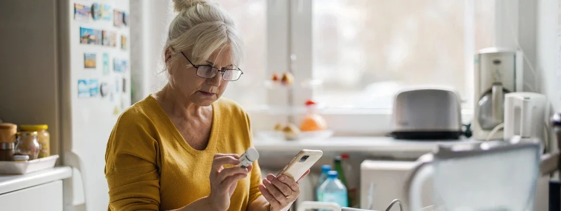 Older woman checking prescription with cell phone. Best Health Insurance Plans for Seniors & Retirees.