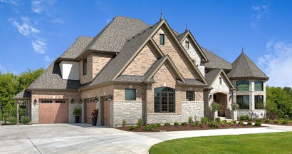 Large home with driveway leading to three car garage. Average cost of Homeowners Insurance.