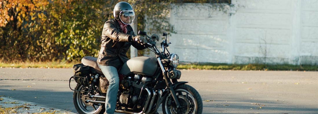 Motorcyclist sits on an old cafe-racer motorcycle. Find Massachusetts motorcycle insurance.