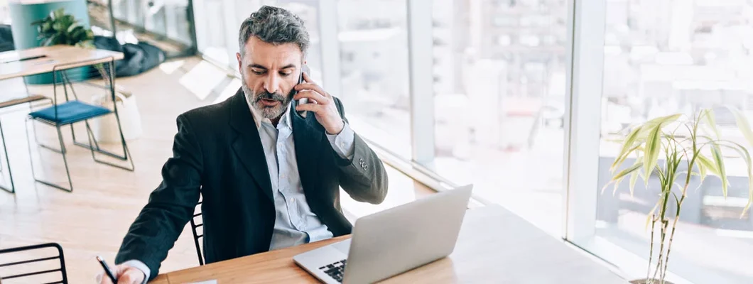 Businessman at the office talking on cell phone. Find New Jersey Errors and Omissions Insurance.