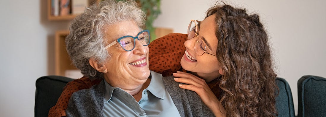 Grandmother and granddaughter laughing and embracing at home. Find Raleigh North Carolina life insurance. 