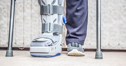 Man with foot injury standing with crutches . Find Personal Injury Insurance.